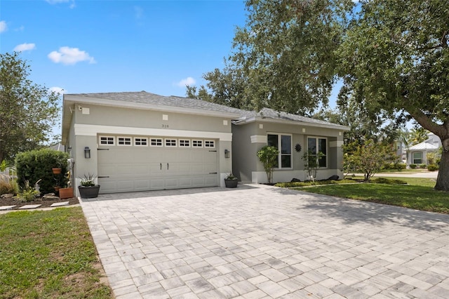 318 39th St NE, Bradenton, FL 34208 - view of front of home featuring decorative driveway, stucco siding, an attached garage, and a front lawn