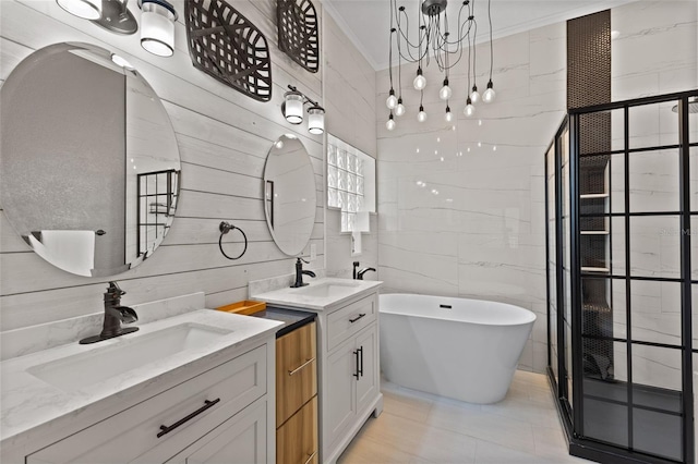 318 39th St NE, Bradenton, FL 34208 - bathroom featuring two vanities, a freestanding tub, a chandelier, crown molding, and tile walls