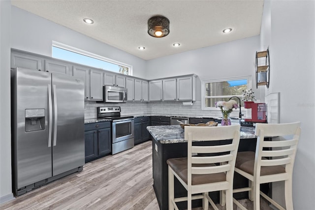 318 39th St NE, Bradenton, FL 34208 - kitchen featuring stainless steel appliances, a peninsula, backsplash, a breakfast bar area, and recessed lighting