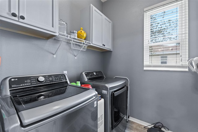 318 39th St NE, Bradenton, FL 34208 - washroom with cabinet space, washing machine and clothes dryer, wood finished floors, and baseboards