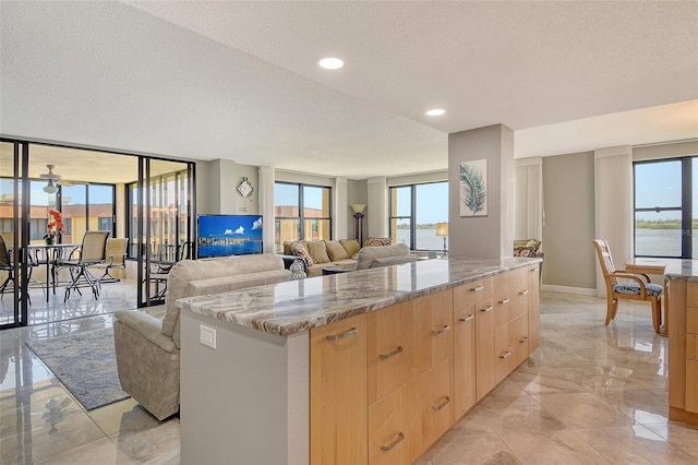 8779 Midnight Pass Rd Unit 506H, Sarasota, FL 34242 - kitchen featuring light brown cabinets, modern cabinets, a textured ceiling, healthy amount of natural light, and a center island
