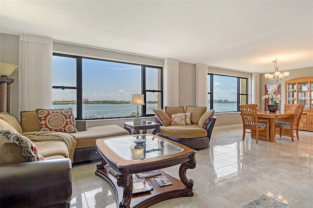 8779 Midnight Pass Rd Unit 506H, Sarasota, FL 34242 - living room with a chandelier, a textured ceiling, light marble finish flooring, a water view, and baseboards