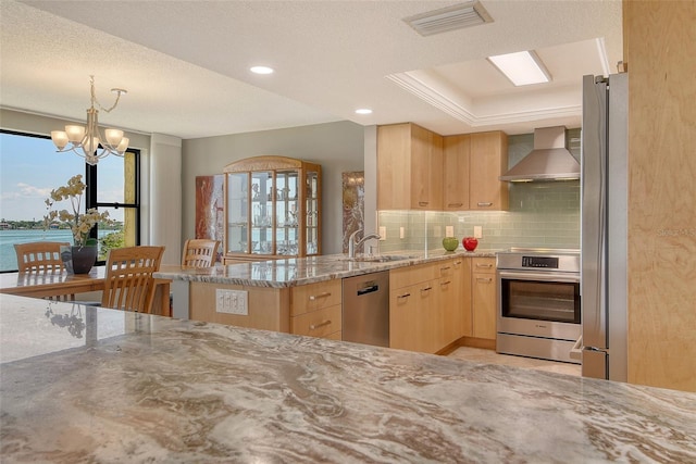 8779 Midnight Pass Rd Unit 506H, Sarasota, FL 34242 - kitchen with light brown cabinets, wall chimney exhaust hood, stainless steel appliances, light stone counters, and tasteful backsplash
