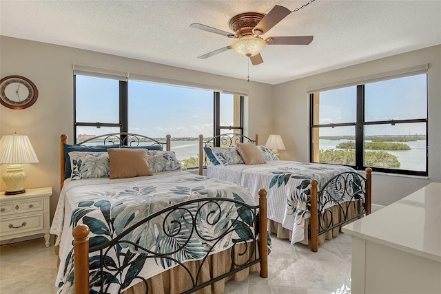 8779 Midnight Pass Rd Unit 506H, Sarasota, FL 34242 - bedroom featuring a water view, ceiling fan, and a textured ceiling