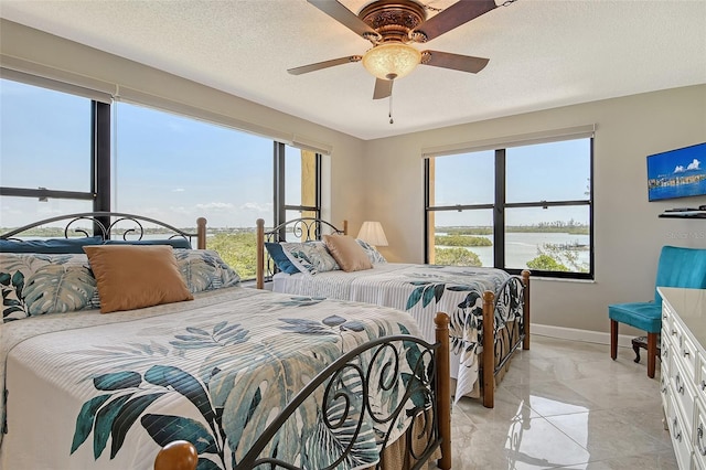 8779 Midnight Pass Rd Unit 506H, Sarasota, FL 34242 - bedroom featuring baseboards, ceiling fan, light marble finish flooring, and a textured ceiling
