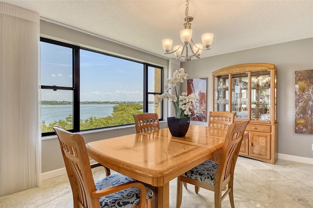 8779 Midnight Pass Rd Unit 506H, Sarasota, FL 34242 - dining area with a chandelier, a textured ceiling, and a water view