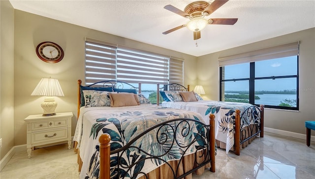 8779 Midnight Pass Rd Unit 506H, Sarasota, FL 34242 - bedroom with multiple windows, a ceiling fan, and a textured ceiling