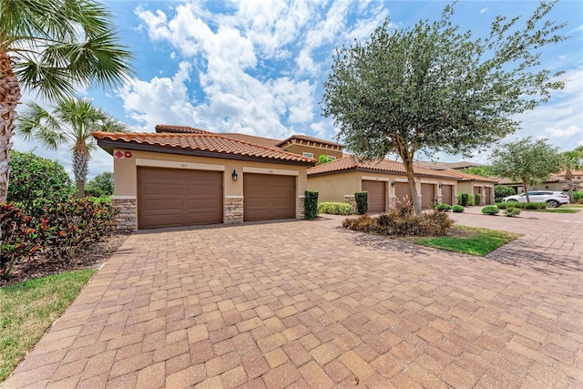 13710 Messina Loop Unit 201, Bradenton, FL 34211 - mediterranean / spanish-style house featuring stucco siding, stone siding, a tile roof, and decorative driveway