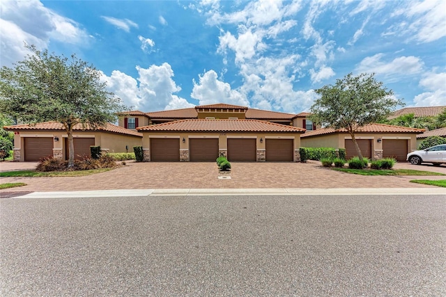13710 Messina Loop Unit 201, Bradenton, FL 34211 - mediterranean / spanish-style house with stucco siding, community garages, stone siding, and a tile roof