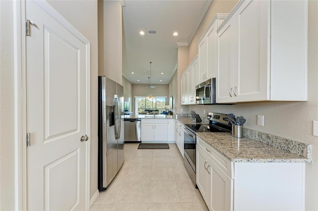 13710 Messina Loop Unit 201, Bradenton, FL 34211 - kitchen featuring appliances with stainless steel finishes, white cabinetry, light tile patterned floors, light stone countertops, and recessed lighting