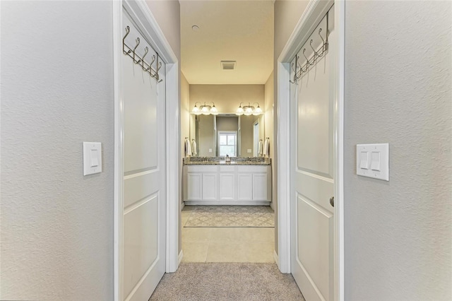 13710 Messina Loop Unit 201, Bradenton, FL 34211 - hall featuring a textured wall, light tile patterned flooring, and light colored carpet