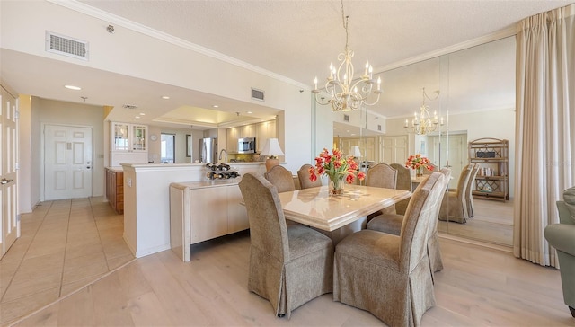 1465 Gulf Of Mexico Dr Unit 502, Longboat Key, FL 34228 - dining space featuring a chandelier, crown molding, light wood finished floors, and a textured ceiling