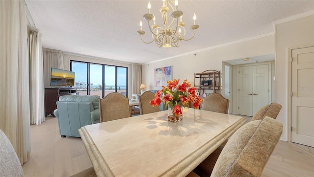 1465 Gulf Of Mexico Dr Unit 502, Longboat Key, FL 34228 - dining room with a textured ceiling, a chandelier, light wood-style floors, and ornamental molding