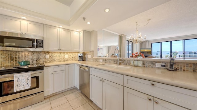 1465 Gulf Of Mexico Dr Unit 502, Longboat Key, FL 34228 - kitchen with stainless steel appliances, a sink, a chandelier, decorative backsplash, and light tile patterned floors