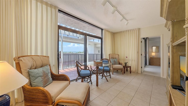 1465 Gulf Of Mexico Dr Unit 502, Longboat Key, FL 34228 - sitting room featuring track lighting, a textured ceiling, light tile patterned floors, and a wall of windows