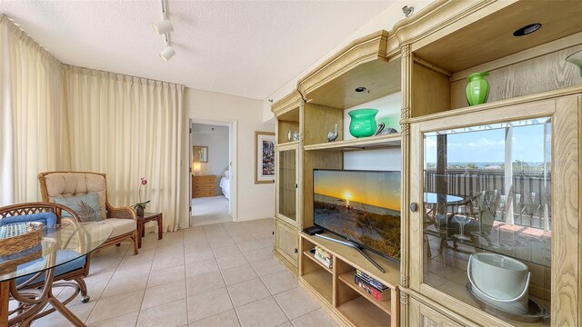 1465 Gulf Of Mexico Dr Unit 502, Longboat Key, FL 34228 - sitting room featuring light tile patterned floors, rail lighting, and a textured ceiling