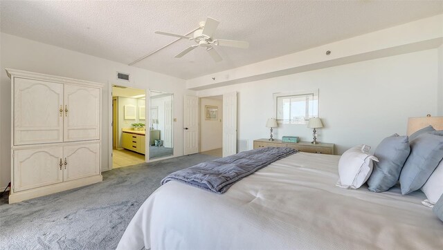 1465 Gulf Of Mexico Dr Unit 502, Longboat Key, FL 34228 - bedroom with light carpet, a textured ceiling, ensuite bath, and a ceiling fan