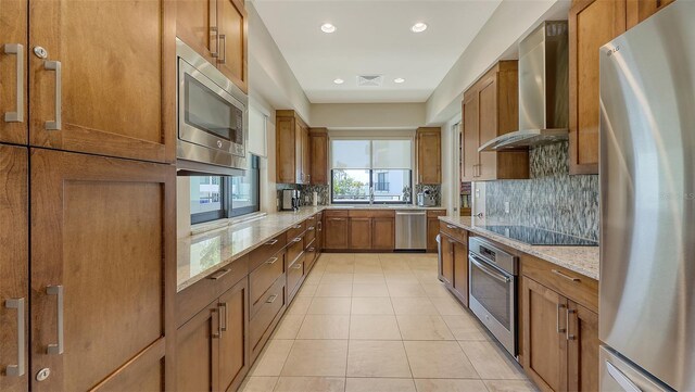 1465 Gulf Of Mexico Dr Unit 502, Longboat Key, FL 34228 - kitchen with appliances with stainless steel finishes, wall chimney exhaust hood, brown cabinetry, and recessed lighting