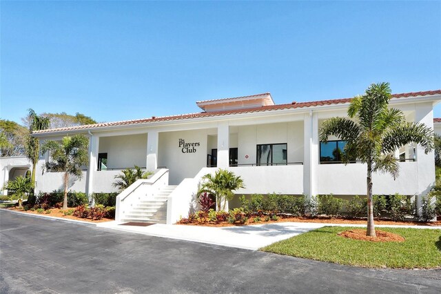 1465 Gulf Of Mexico Dr Unit 502, Longboat Key, FL 34228 - view of front of home featuring stairs, a tile roof, stucco siding, and a porch
