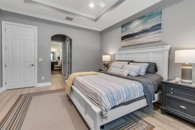 932 Mangrove Edge Ct, Bradenton, FL 34208 - bedroom featuring arched walkways, light wood-type flooring, crown molding, a raised ceiling, and recessed lighting