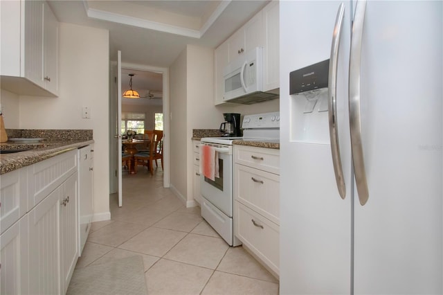 3745 Almeria Ave Unit 7S, Sarasota, FL 34239 - kitchen featuring white appliances, white cabinets, and light tile patterned floors