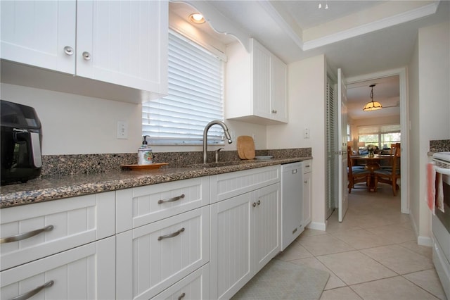 3745 Almeria Ave Unit 7S, Sarasota, FL 34239 - kitchen with white dishwasher, a sink, white cabinets, dark stone countertops, and light tile patterned flooring