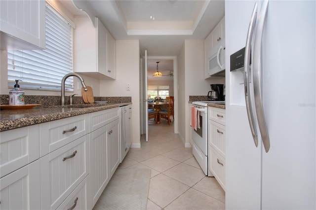 3745 Almeria Ave Unit 7S, Sarasota, FL 34239 - kitchen featuring white appliances, a sink, white cabinets, and a raised ceiling