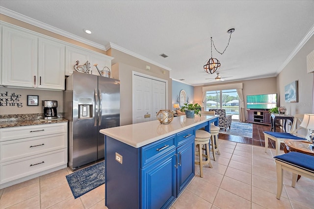 12322 Tall Pines Way, Lakewood Ranch, FL 34202 - kitchen with stainless steel fridge with ice dispenser, blue cabinets, ornamental molding, white cabinets, and a breakfast bar