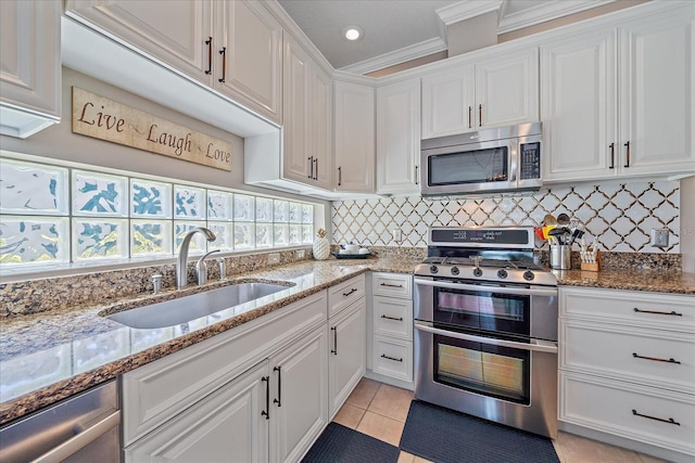 12322 Tall Pines Way, Lakewood Ranch, FL 34202 - kitchen with appliances with stainless steel finishes, a sink, white cabinets, crown molding, and decorative backsplash