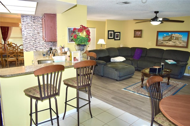 6704 Rosemary Dr, Tampa, FL 33625 - living area featuring ceiling fan, light tile patterned floors, and a textured ceiling