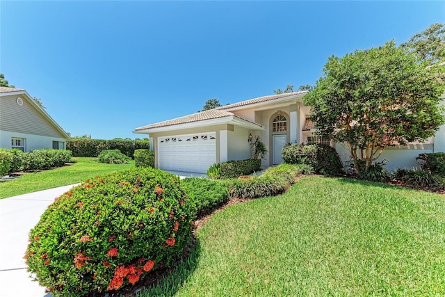 7023 Woodside Oaks Cir Unit 1, Sarasota, FL 34231 - view of front of home with a front yard, a garage, stucco siding, and a tile roof