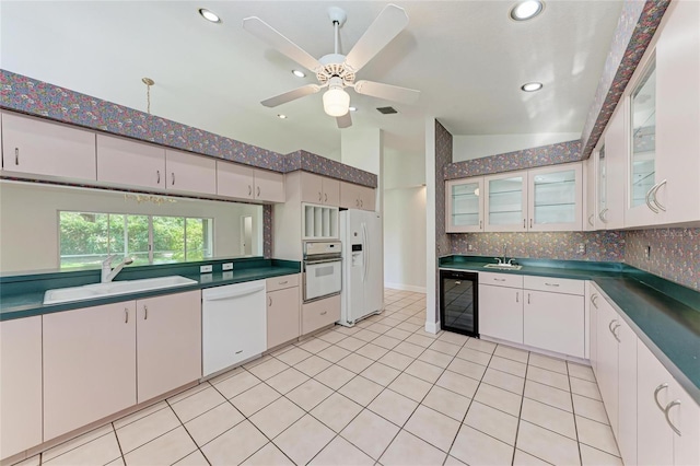 7023 Woodside Oaks Cir Unit 1, Sarasota, FL 34231 - kitchen featuring white appliances, a sink, wine cooler, decorative backsplash, and dark countertops