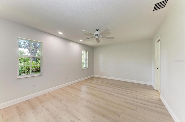 7023 Woodside Oaks Cir Unit 1, Sarasota, FL 34231 - empty room with a ceiling fan, recessed lighting, light wood finished floors, baseboards, and a textured ceiling