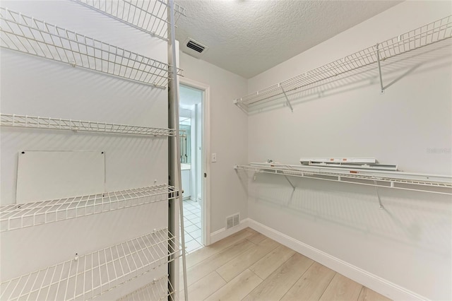 7023 Woodside Oaks Cir Unit 1, Sarasota, FL 34231 - walk in closet featuring light wood-type flooring