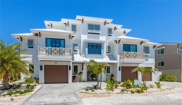 401 39th St, Holmes Beach, FL 34217 - view of front of house featuring a balcony, an attached garage, decorative driveway, and stucco siding