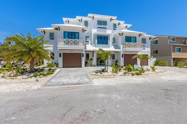 401 39th St, Holmes Beach, FL 34217 - view of front facade featuring a balcony, a garage, driveway, and stucco siding