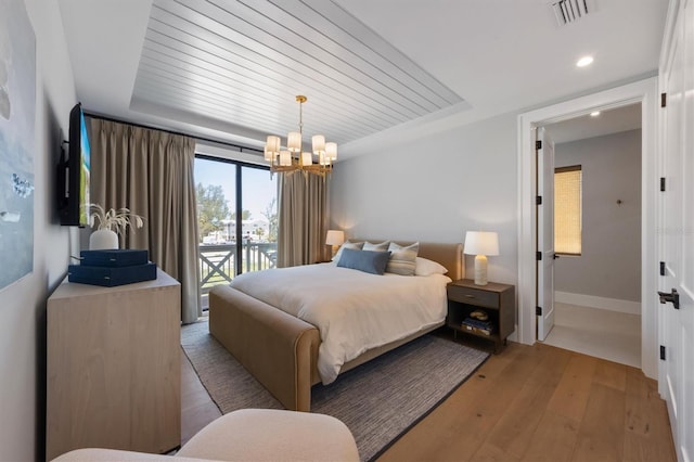 401 39th St, Holmes Beach, FL 34217 - bedroom featuring a chandelier, access to outside, light wood finished floors, a raised ceiling, and recessed lighting