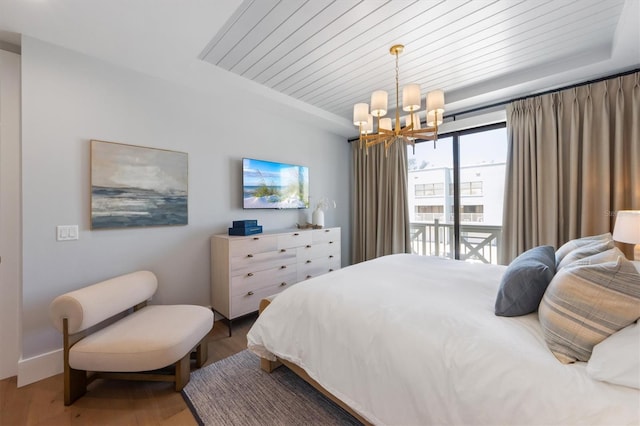 401 39th St, Holmes Beach, FL 34217 - bedroom featuring a chandelier, wood finished floors, wood ceiling, baseboards, and access to outside