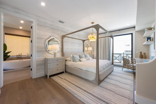401 39th St, Holmes Beach, FL 34217 - bedroom with wood finished floors, a chandelier, recessed lighting, and access to exterior