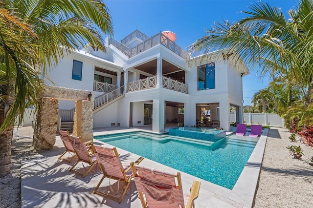 401 39th St, Holmes Beach, FL 34217 - back of property featuring a balcony, a patio, stucco siding, stairway, and a pool with connected hot tub