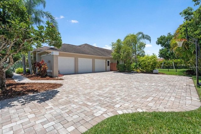 7321 Hemlock Ln, Sarasota, FL 34241 - view of front of house featuring an attached garage, stucco siding, and decorative driveway