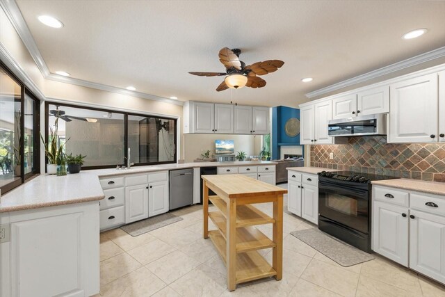 7321 Hemlock Ln, Sarasota, FL 34241 - kitchen featuring appliances with stainless steel finishes, ceiling fan, crown molding, tasteful backsplash, and white cabinetry
