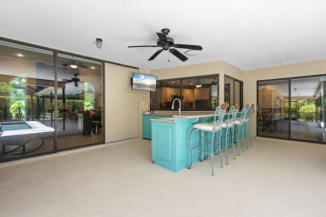 7321 Hemlock Ln, Sarasota, FL 34241 - kitchen with ceiling fan, a kitchen bar, a sink, light countertops, and blue cabinets