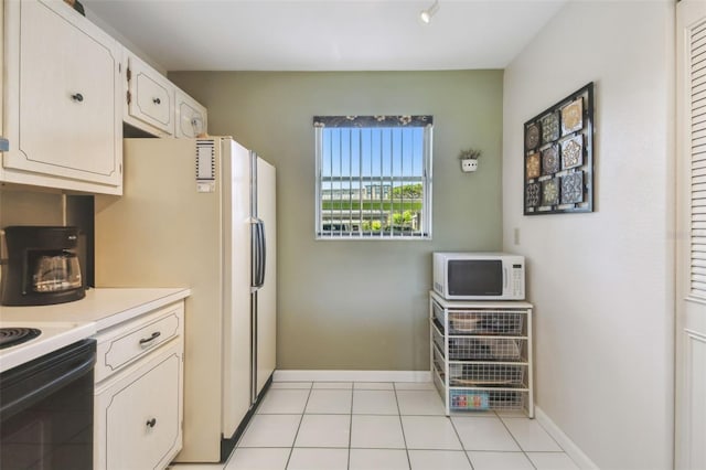 3820 Ironwood Ln Unit 104-I, Bradenton, FL 34209 - kitchen featuring white microwave, light countertops, range with electric stovetop, baseboards, and white cabinetry