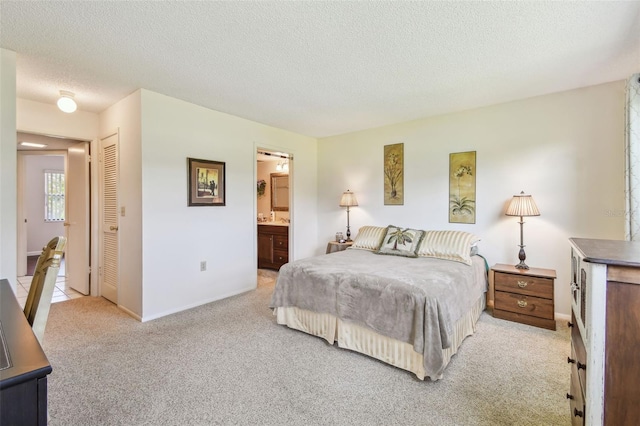 3820 Ironwood Ln Unit 104-I, Bradenton, FL 34209 - bedroom with light carpet, a textured ceiling, a closet, connected bathroom, and baseboards