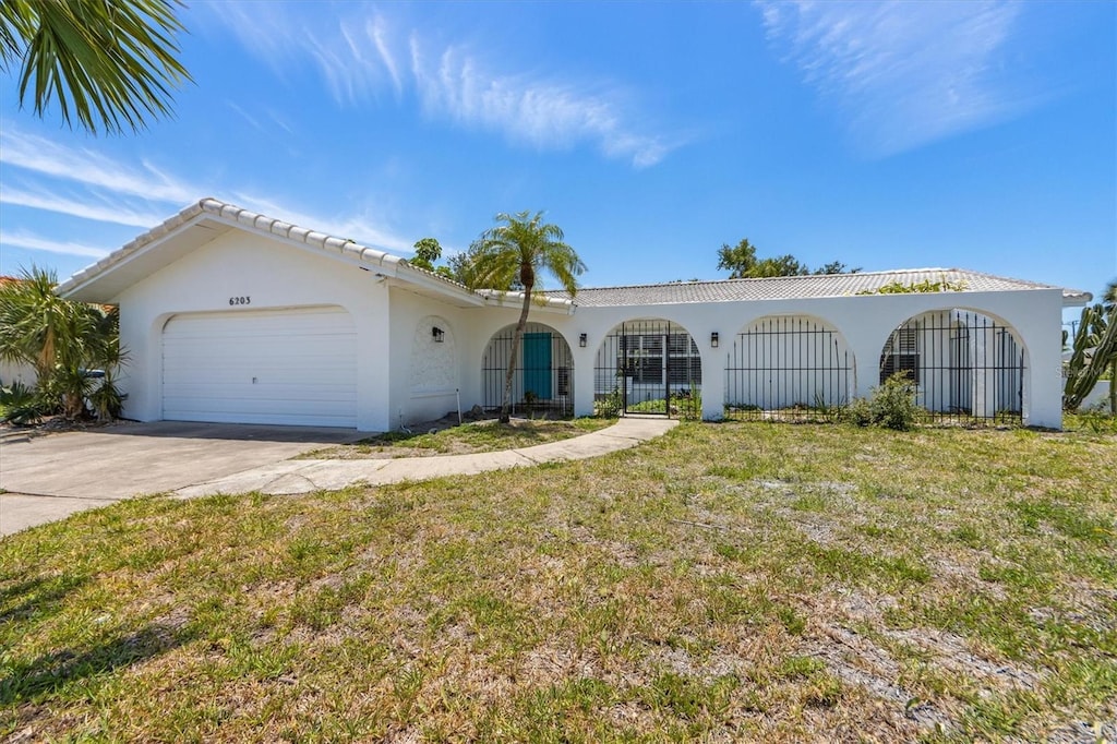 6203 11th Ave W, Bradenton, FL 34209 - single story home featuring stucco siding, an attached garage, driveway, and a front lawn