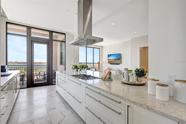33 S Palm Ave Unit 1101, Sarasota, FL 34236 - kitchen featuring island exhaust hood, modern cabinets, gas cooktop, light marble finish floors, and white cabinets
