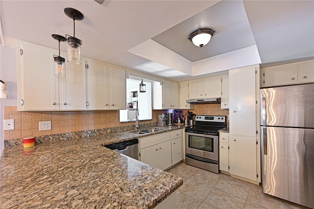 3417 49th St W, Bradenton, FL 34209 - kitchen with appliances with stainless steel finishes, under cabinet range hood, a sink, tasteful backsplash, and dark stone counters