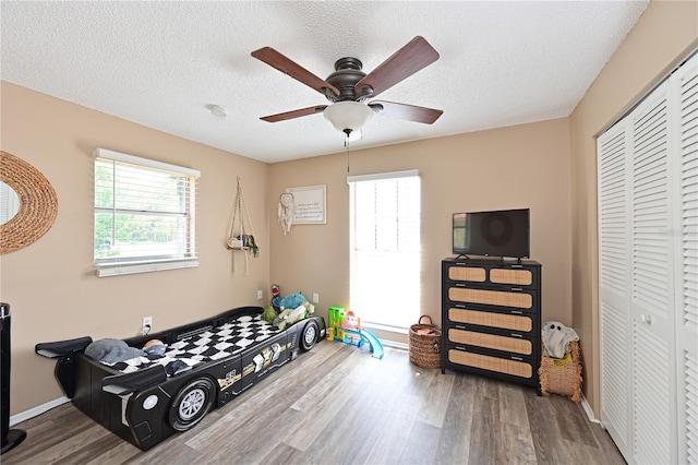 3417 49th St W, Bradenton, FL 34209 - bedroom featuring wood finished floors, a closet, a textured ceiling, a ceiling fan, and baseboards