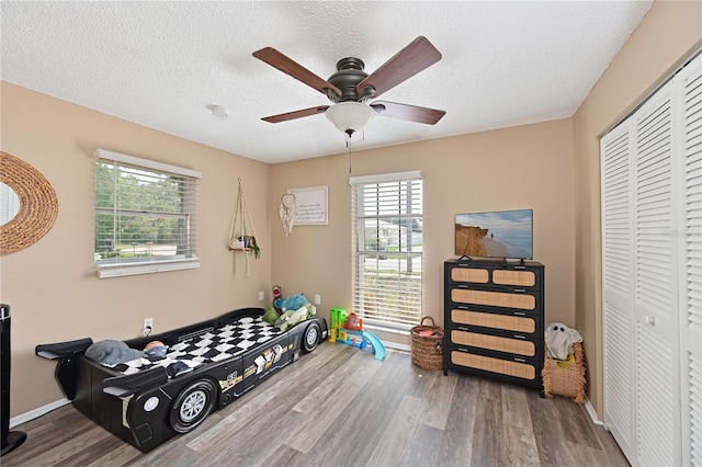 3417 49th St W, Bradenton, FL 34209 - workout area with wood finished floors, healthy amount of natural light, ceiling fan, a textured ceiling, and baseboards